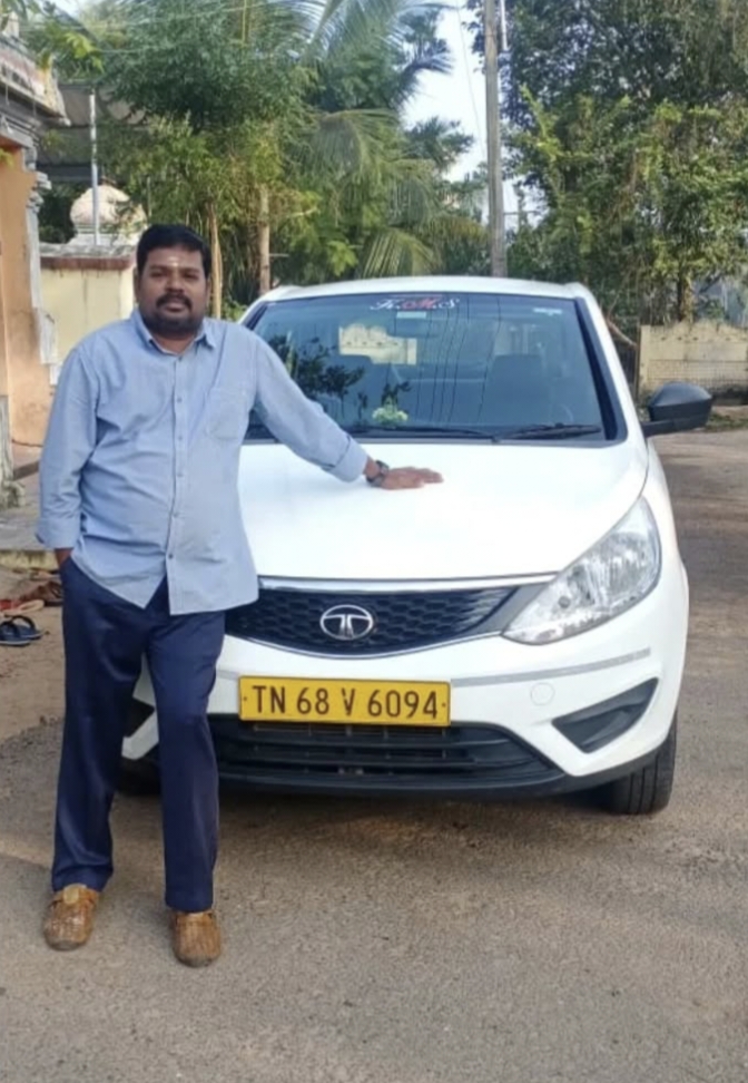 Owner of Kumbakonam Safety Travels standing beside one of the fleet cars